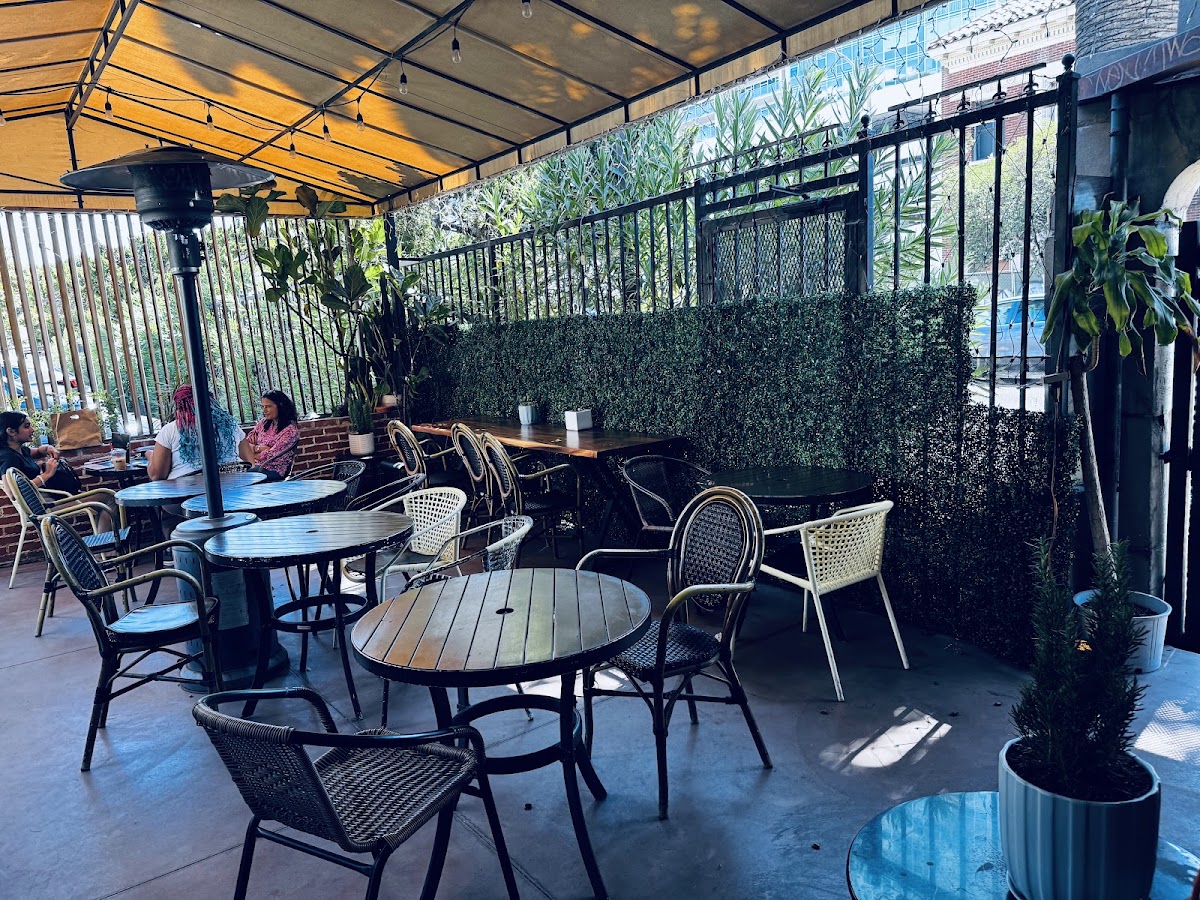 The covered patio at Cafe Loft with rattan chairs, heaters and string lights