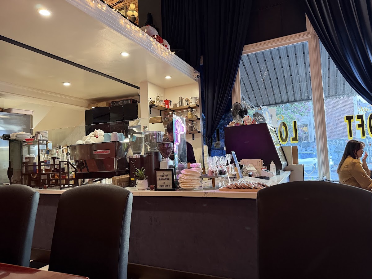 The marble counter at Cafe Loft with the espresso machine, pastry case and navy curtains